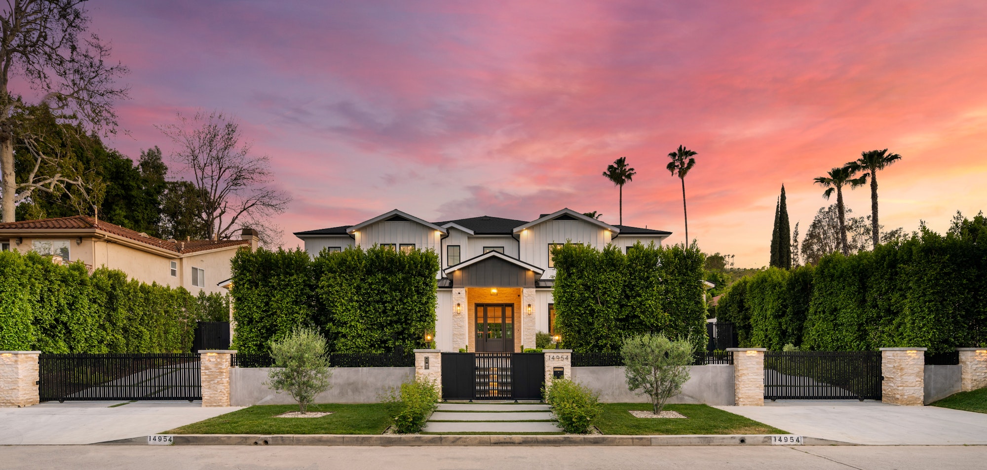 an outside view of a home in the sunset with palm trees